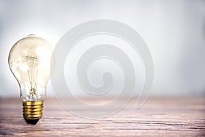 Lightbulb shining on wooden shelf with copy space, idea and creative concept background, dea and Creative concept for