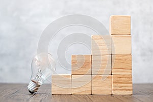 Lightbulb and wood block stack of building with business idea, creative, thinking goal, strategy and innovation concept