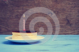 Lighted birthday candle on a cheesecake, with a retro effect photo