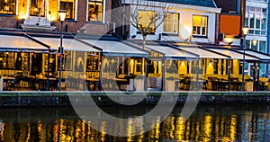 Lighted buildings with terraces at night, beautiful water scenery in the city of Alphen aan den Rijn, The netherlands