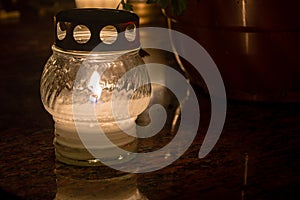 Lighted candle on the grave at All Saints` Day