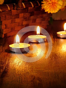 Lighted candles and a wicker basket with a pumpkin and flowers