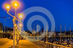 Lighted lampposts at night in the harbor of blankenberge, popular city in belgium, city architecture in the evening