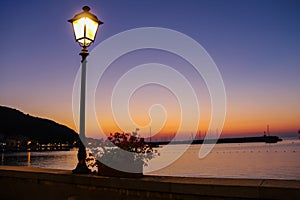 Lighted lantern on coast of the Tyrrhenian Sea on the sunset