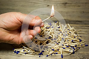 A lighted match in his hand