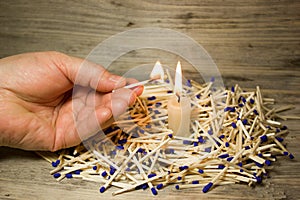A lighted match in his hand and the candle