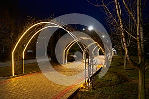 Lighted walkway in a night park.