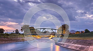 Lighten, metal railroad bridge over motion blurred river panorama