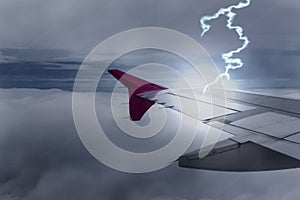 Lightening strikes aircraft wing of airplane on dark sky