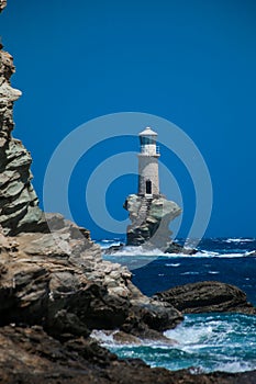 Lighthouse in andros island greece in day light and sea waves