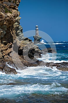 Lighthouse in andros island greece in day light and sea waves