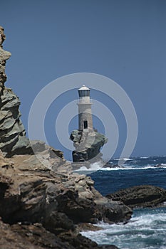 Lighthouse in andros island greece in day light and sea waves