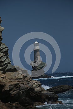 Lighthouse in andros island greece in day light and sea waves