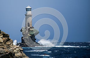 Lighthouse in andros island greece in day light and sea waves