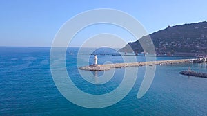 Lighthouse on background of seascape and coastal city. Clip. Top view of beautiful seascape with white lighthouse off