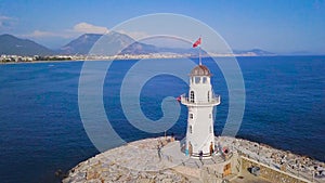 Lighthouse on background of seascape and coastal city. Clip. Top view of beautiful seascape with white lighthouse off