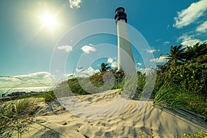 Lighthouse on the beach of the Atlantic Ocean among tropical plants.