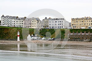 Lighthouse on beach and seafront houses