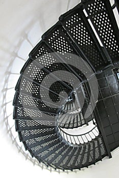 Lighthouse black metal spiral staircase with landing and shadows