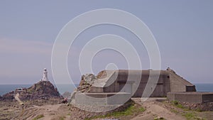 A lighthouse and blockhouse built on a rocky beach