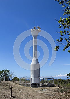 Lighthouse and blue sky, Apo island, Philippines. Modern lighthouse on hill under sun