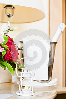 Lighthouse candle holder with champagne bottle and flower basket in the upscale hotel room. Being alone, getaway