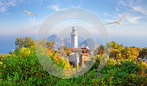 Lighthouse at Cape Gelidonia among green trees and seagulls in sky