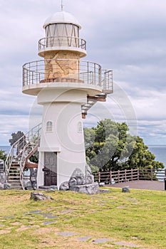 Lighthouse on cliff in park overlooking Hubo seaport photo