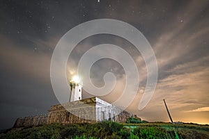 Lighthouse with clouds and stars