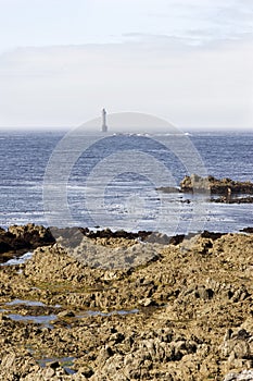 Lighthouse by the coast in Britain with clouds