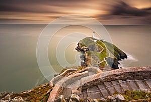 Lighthouse on coastal island with horizon and beautiful sunset