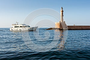 Lighthouse and cruise ship on the shore of Greece in Crete