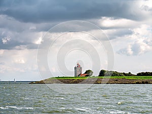 Lighthouse De Ven on dyke of IJsselmeer lake, Noord-Holland, Netherlands photo