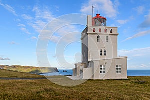 Lighthouse on Dyrholaey peninsula and views of Mount Reynisfjall, Reynisdrangar cliffs and part of the famous Reynisfjara beach photo
