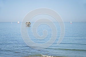 Lighthouse at the end of the world in Atlantic ocean on sunny day