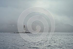 Lighthouse in a foggy sea show the direction - loneliness and hope concept