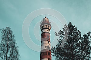 Lighthouse in the forest among the trees. red and white lighthouse