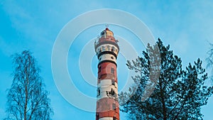 Lighthouse in the forest among the trees. red and white lighthouse