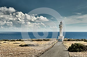 Lighthouse on the Formentera island, Spain, the blue sky with white clouds, without people, car is on a path to photo