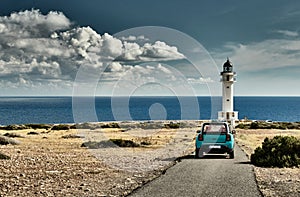 Lighthouse on the Formentera island, Spain, the blue sky with white clouds, without people, car is on a path to photo