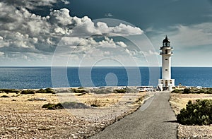 Lighthouse on the Formentera island, Spain, the blue sky with white clouds, without people, car is on a path to photo