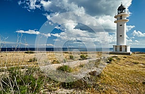 Lighthouse on the Formentera island, Spain, the blue sky with white clouds, without people, rocks, stones, sunny weather photo