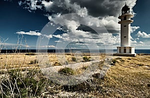 Lighthouse on the Formentera island, Spain, the blue sky with white clouds, without people, rocks, stones, sunny weather photo