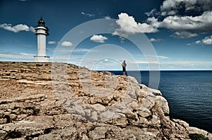 Lighthouse on the Formentera island, Spain, the blue sky with white clouds, The person with a bag on the edge of the photo