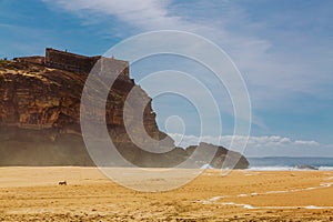 Lighthouse and Fort of Sao Miguel above North beach at Nazare, Portugal