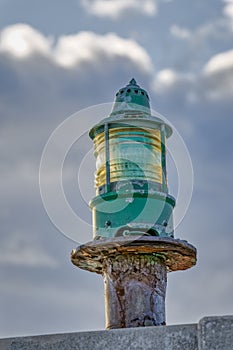 Lighthouse green beacon against blue sky