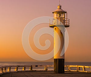 The lighthouse on the harbor pier of Blankenberge, Belgium, popular architecture at sunset