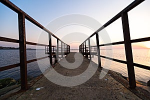 Lighthouse during a last minute of sunset with a big sun close to the horizon and clear sky