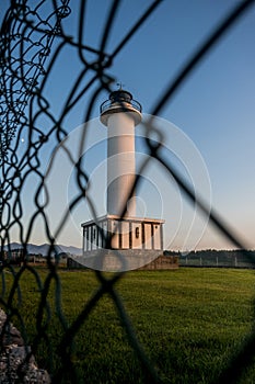 Lighthouse of Lastres with the fence on the foreground captured in the town of Luces, Spain photo