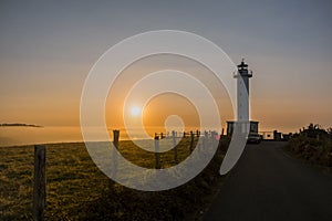 Lighthouse of Lastres at sunset captured in the town of Luces, Spain photo